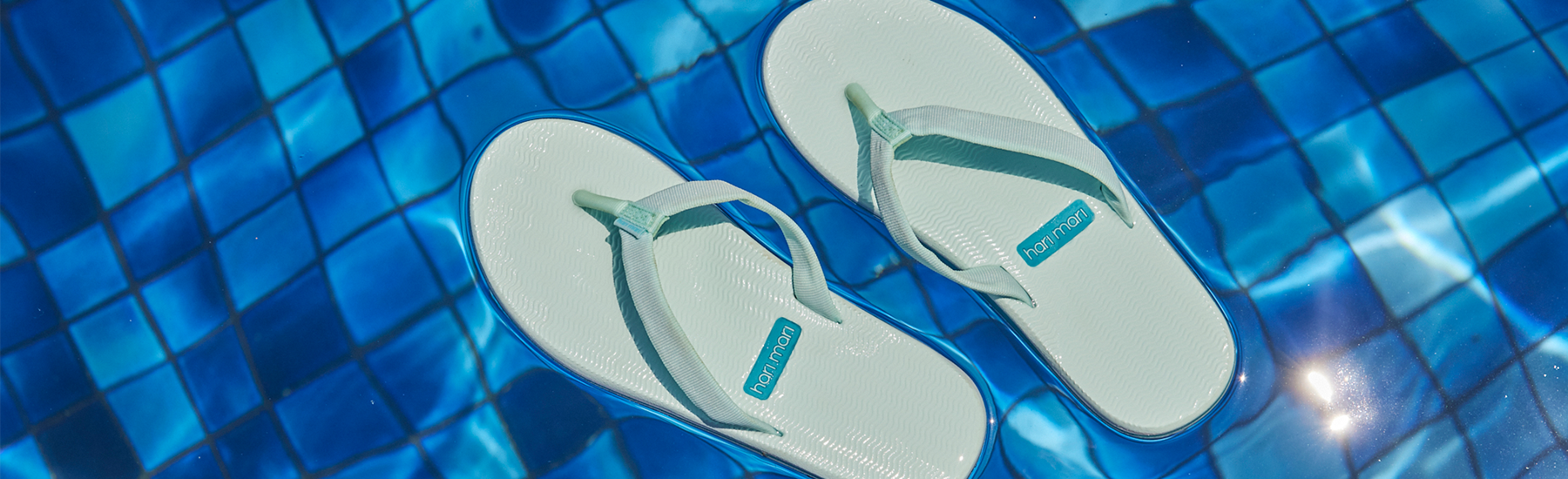 Hari Mari Dunes flip flops in Sea Glass floating in a swimming pool