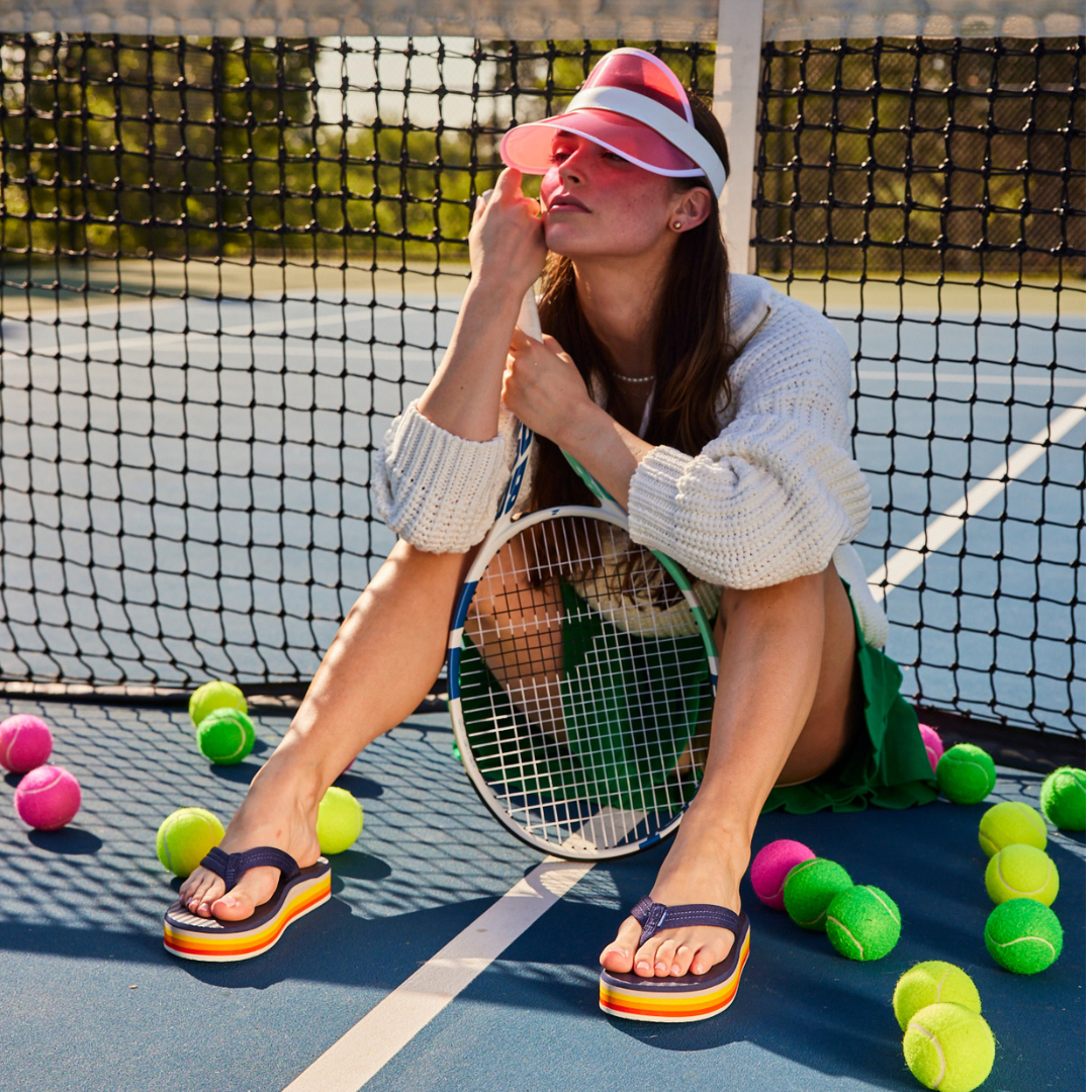 woman posing on tennis court wearing trendy platform sandals for women from Hari Mari