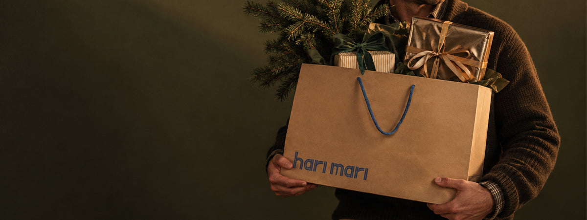 Man holding bag of gifts against a green background