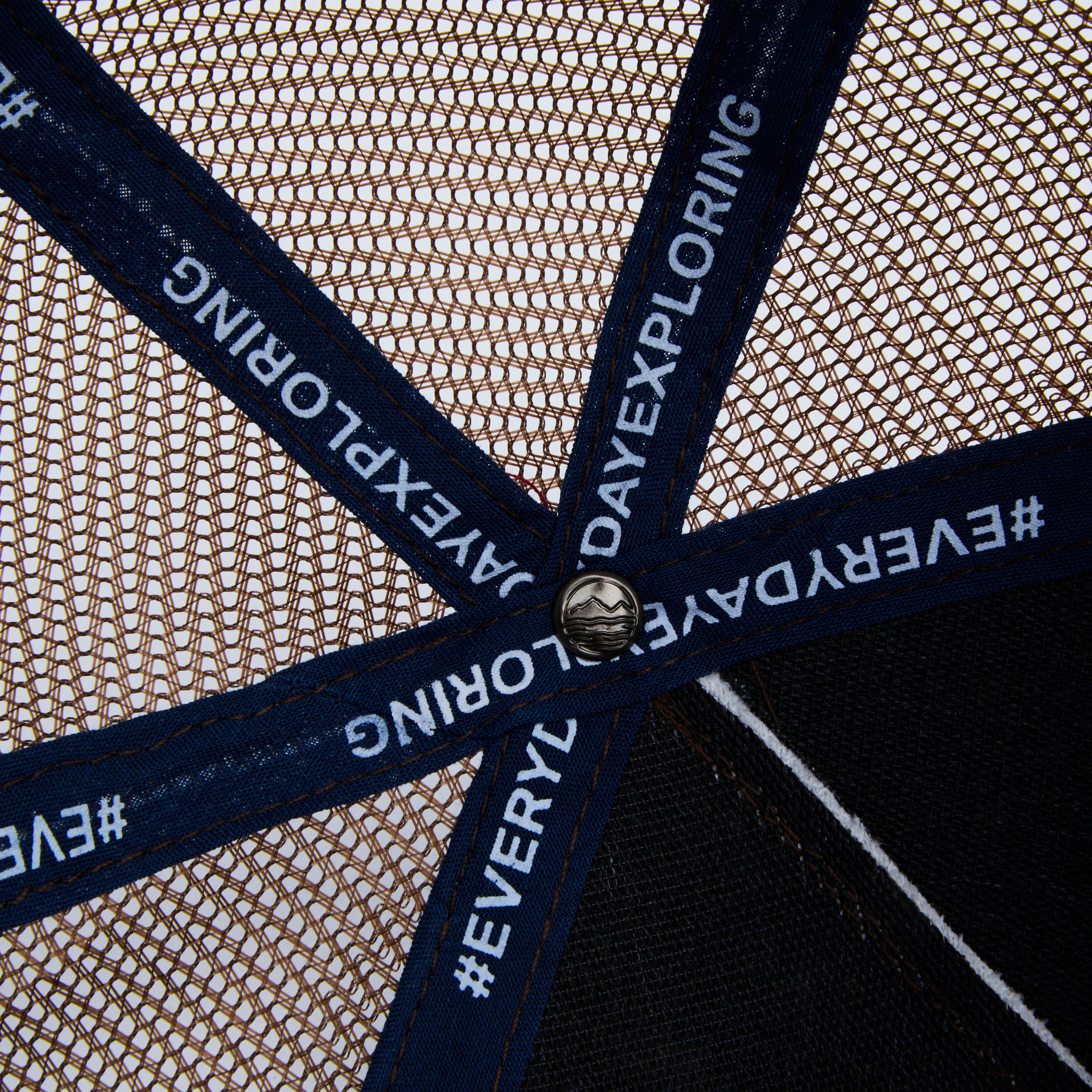 Close-up of a trucker hat with 'Everyday Exploring' branding on the mesh back.