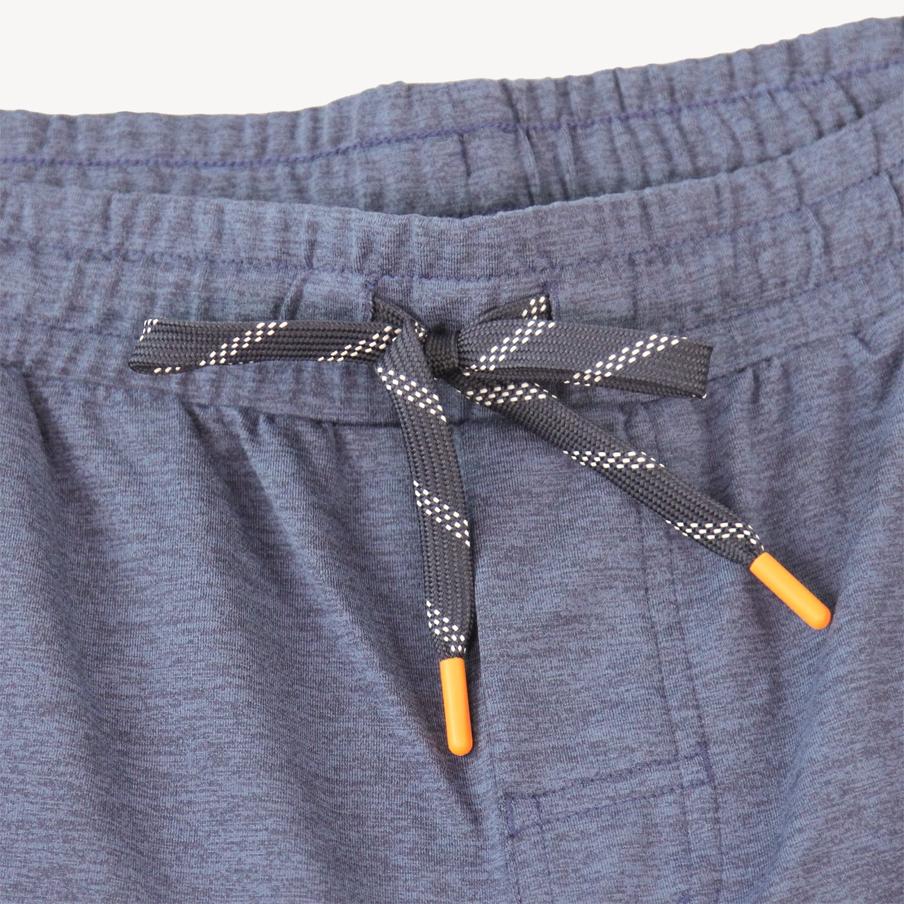 Close-up of a pair of Hari Mari heathered navy athletic shorts showing the elastic waistband and a dark gray drawstring with white dotted pattern and orange tips.