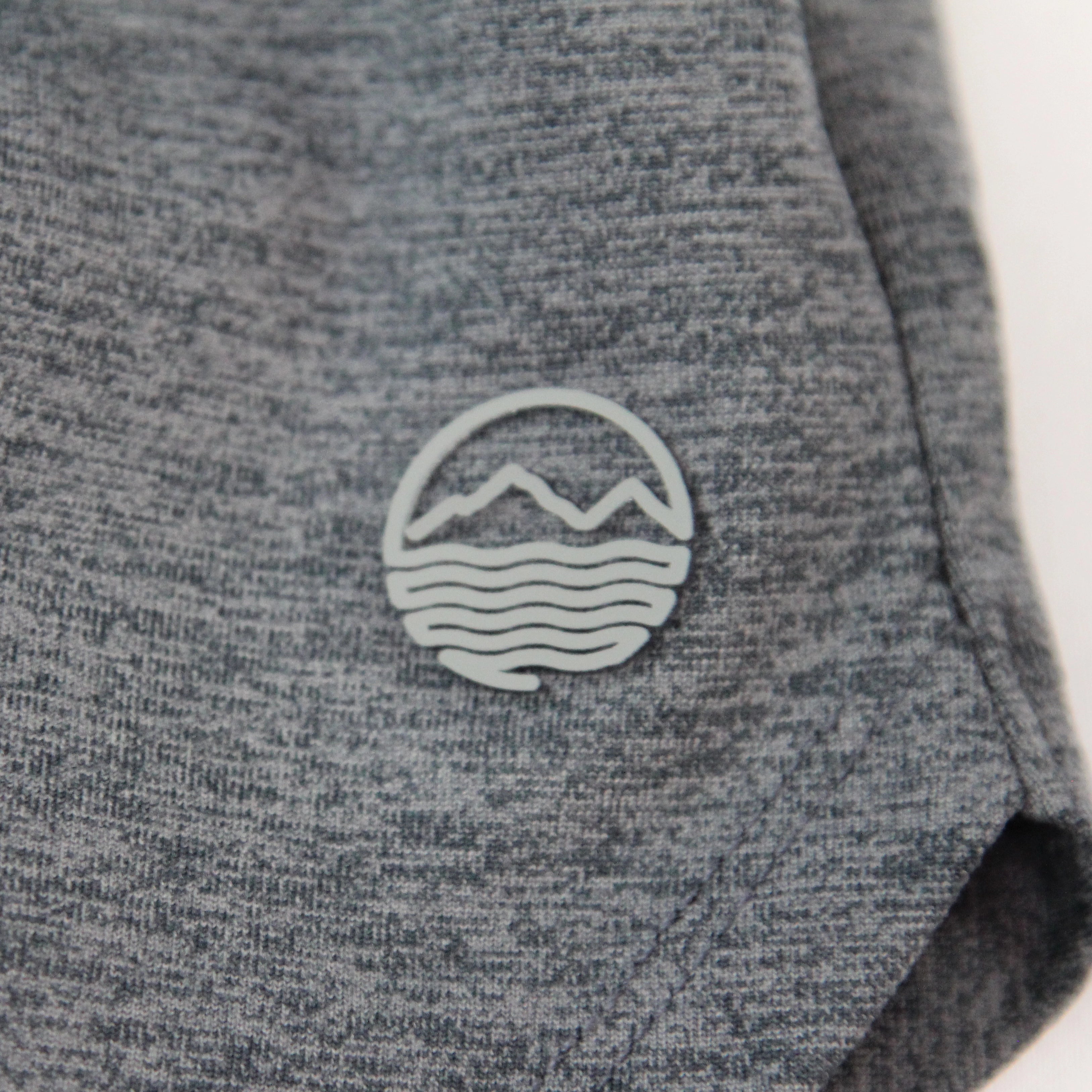 Close-up of heather gray shorts for women with a small Hari Mari logo featuring a mountain and wave design in light gray.