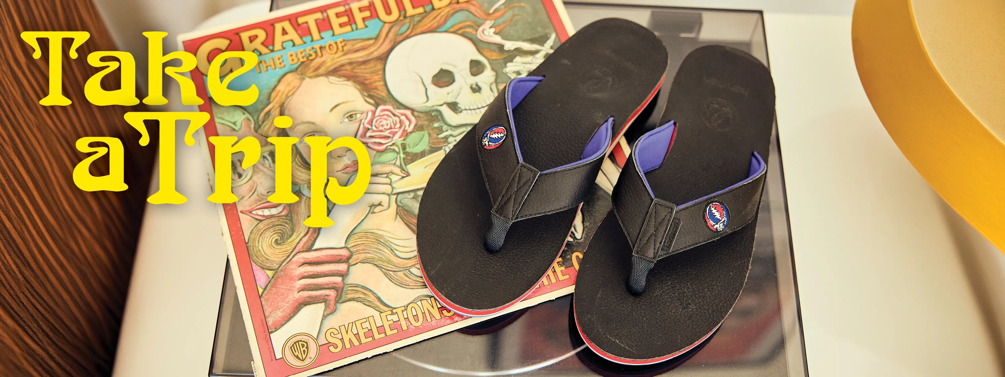 pair of black Grateful Dead x Hari Mari flip flops on a Grateful Dead record
