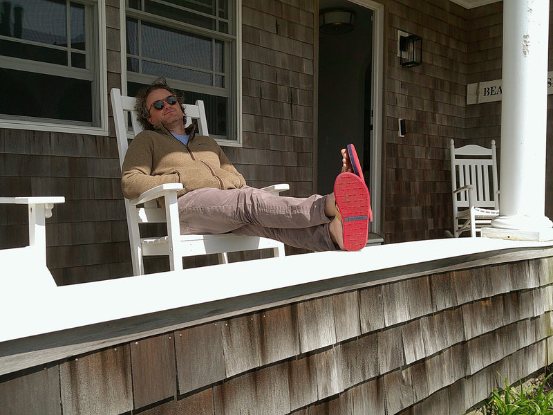 man sleeping on a porch wearing Hari Mari flip flops