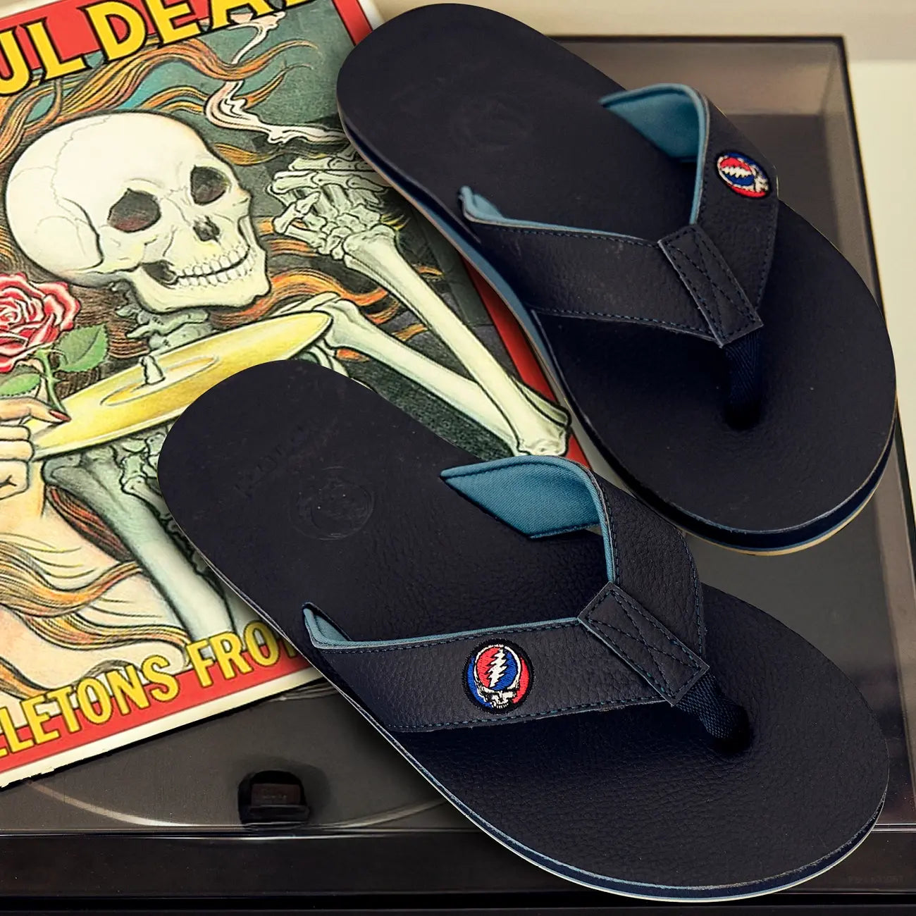 Black flip-flops with a Grateful Dead Stealie patch on a record cover