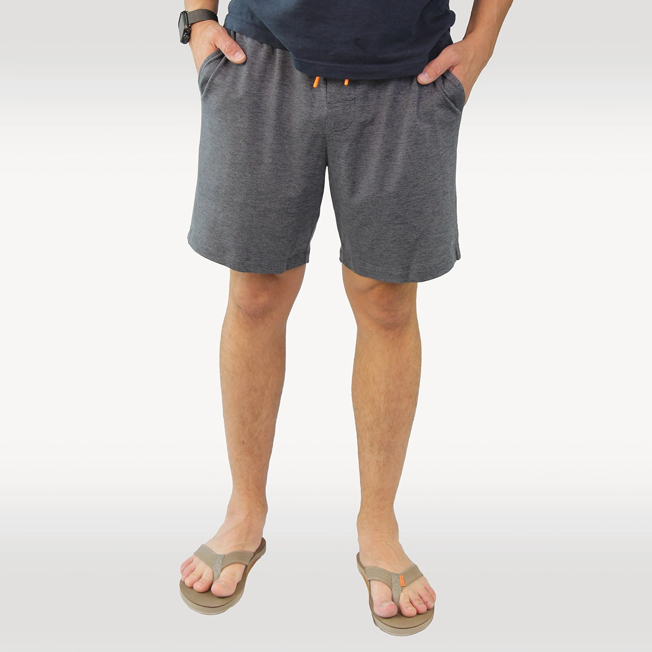 A man wearing heather gray drawstring shorts with side pockets from Hari Mari, paired with a dark navy t-shirt, shown from the chest down against a plain white background.