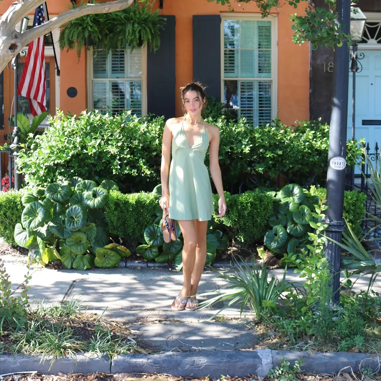 woman wearing Shep Rose x Hari Mari flip flops with a green dress in charleston