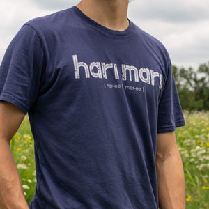 image of man wearing navy tee shirt with white chest graphic in flowery field