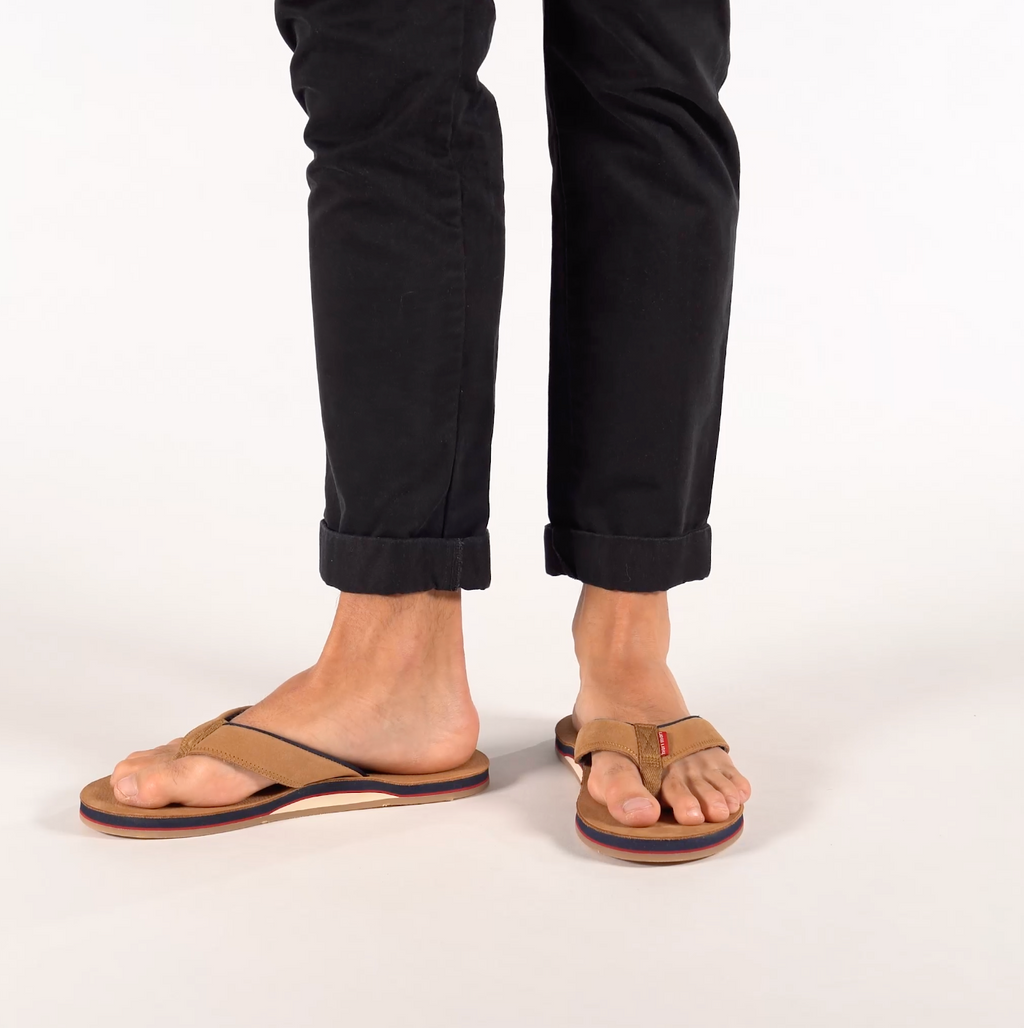 man walking in tan flip flops 