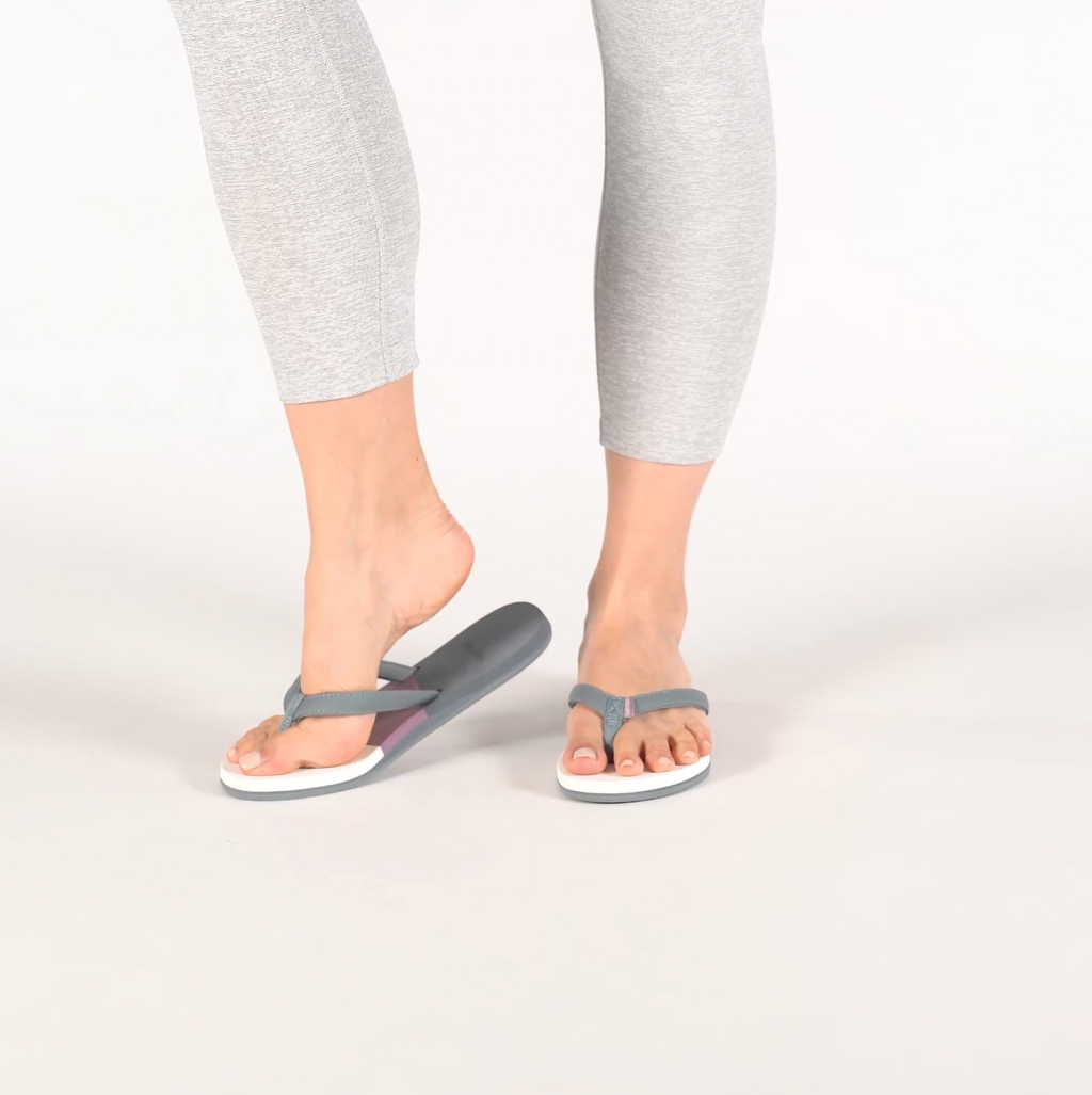 woman walking in gray and purple flip flops