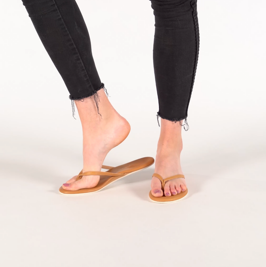 Video of woman walking in tan flip flops